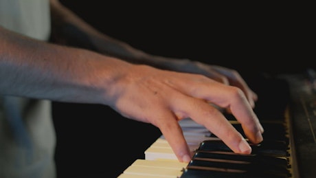 Hands of a skillful pianist playing a keyboard.
