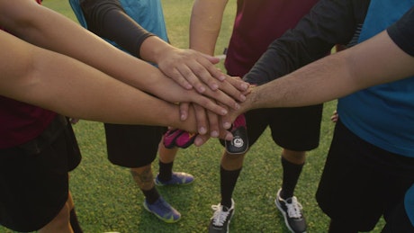 Hands of a soccer team making a cheer.