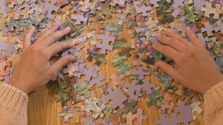 Hands of a woman playing with a puzzle