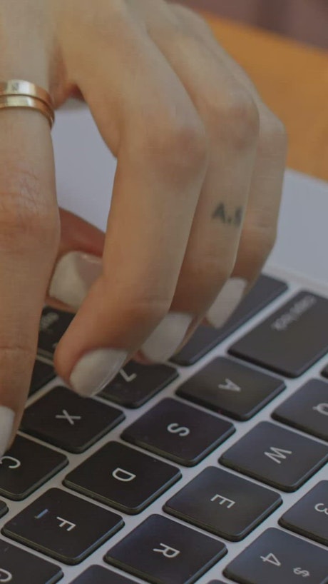 Hands of a woman working on a computer.
