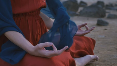 Hands of a woman yoga position on the land of a desert