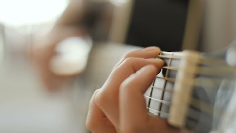 Hands playing an acoustic guitar