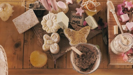 Hands selecting and packaging handmade soaps.