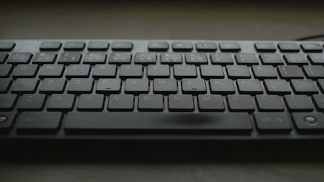 Hands typing on a black keyboard.