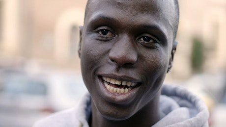Handsome young black man smiling with white teeth.