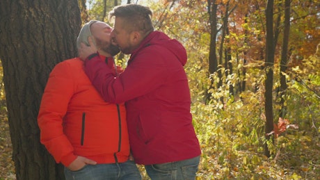 Happy couple sharing a kiss on an autumn day.