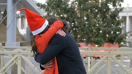 Happy festive couple at Christmas hugging.