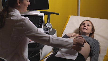 Happy pregnant woman having an ultrasound.