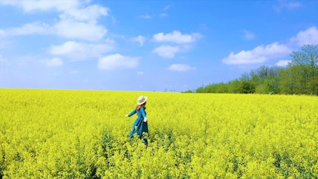 Happy woman spinning on a flower field