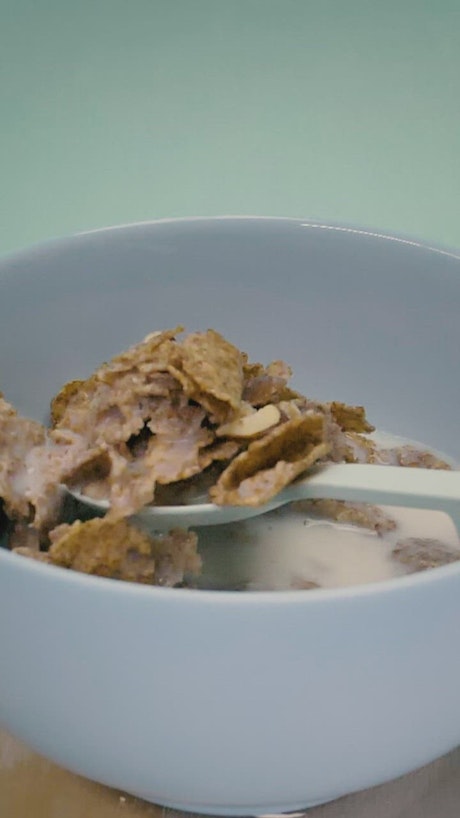 Having a tablespoon of healthy cereal with milk.