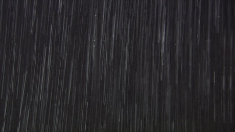Heavy rain on a dark screen