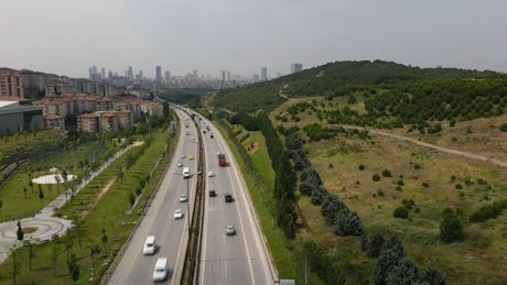 Highway surrounded by nature and buildings.