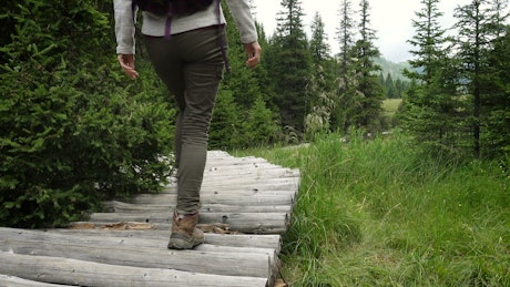 Hiker woman going through a wooden path