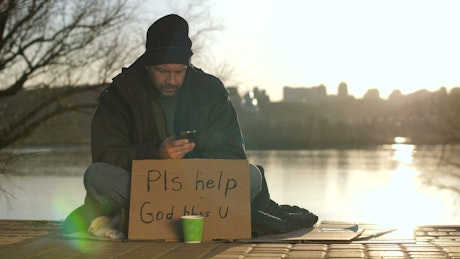 Homeless man with a smartphone.