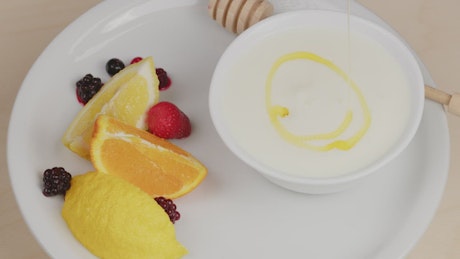 Honey drops on a plate with yogurt.