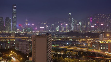 Hong Kong city skyline and overpass at night.