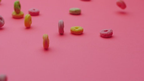 Hoop cereal gliding on a pink surface