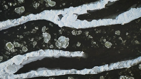 Ice floes in a river filmed from above.
