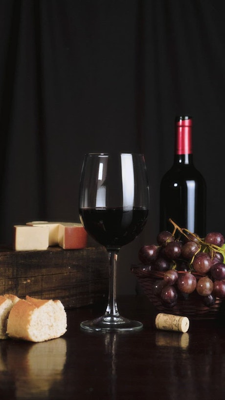 Image composition on a table with wine, cheese, grapes and bread.