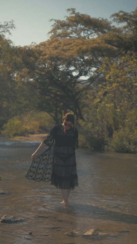 Indie fashion girl walking on a river.