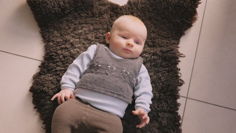 Infant laying on a rug