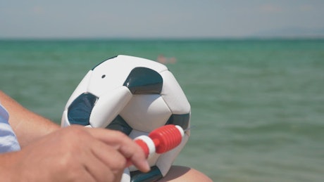 Inflating a ball for a beach game