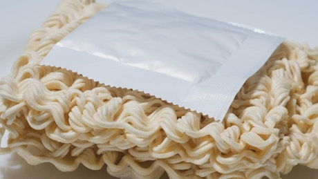 Instant noodles on white rotary surface.