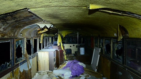Interior of an abandoned bus at night.