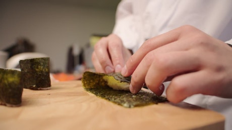 Japanese chef carefully preparing Gunkan Nigiri.
