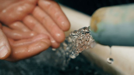 Jet water is poured into the hands of a person
