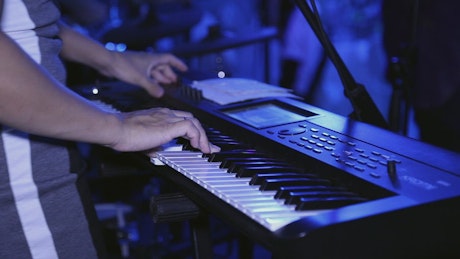 Keyboard player jamming on a synthesizer.