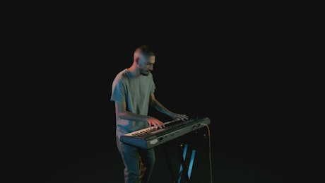 Keyboardist playing in the dark.