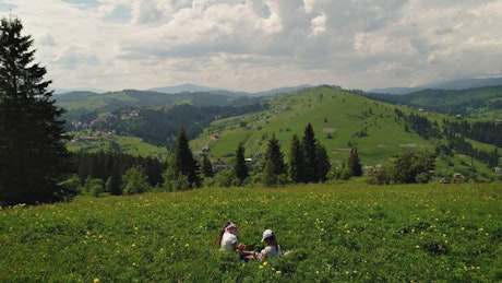 Kids playing at a green hill