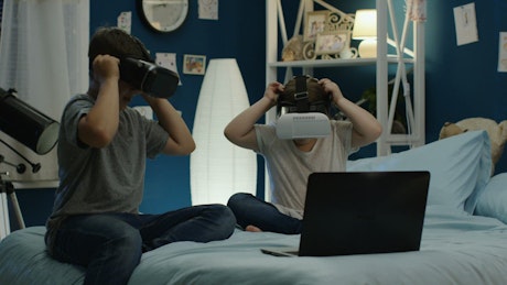 Kids playing with VR technology in the bedroom.