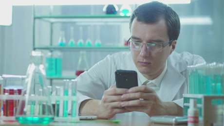 Laboratory scientist looking at the phone.