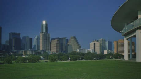 Landscape of a meadow surrounded by trees and buildings