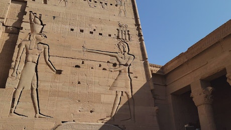 Large carvings of Egyptian Gods on temple ruins.