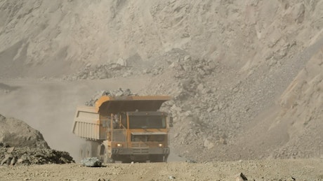 Large dump truck driving a load of rubble from a mine.