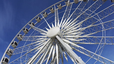 Large Ferris Wheel spinning slowly on a sunny day.