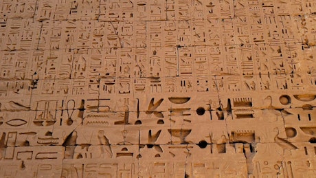 Large stone wall covered in ancient hieroglyphics.