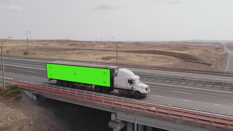 Large truck driving along a rural highway.