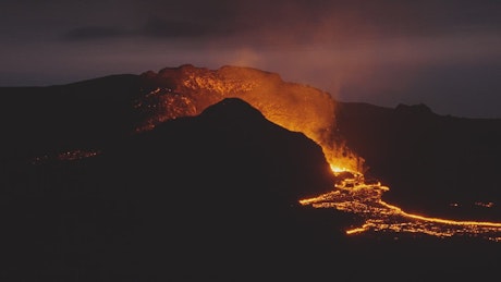 Lava surrounding a volcano during eruption.