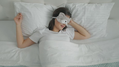 Lazy girl in animal mask sleeps through alarm.