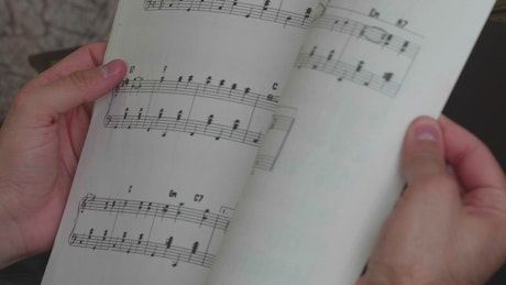 Leafing through a notebook with sheet music