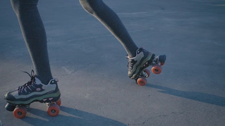 Legs of a girl when skating on concrete.
