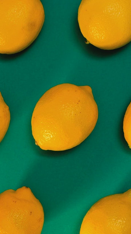 Lemons placed on a green surface.