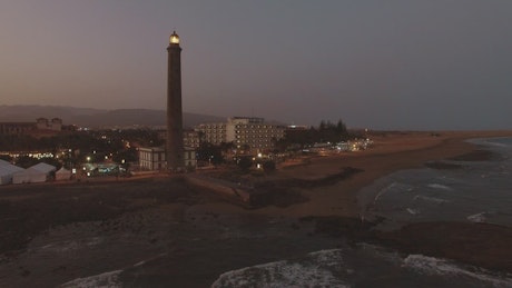 Lighthouse and a hotel at dusk.
