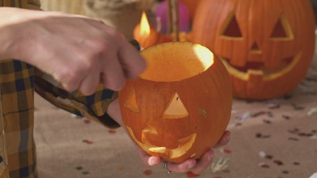 lighting a candle in a halloween pumpkin.