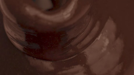Liquid chocolate flowing into a chocolate fountain.