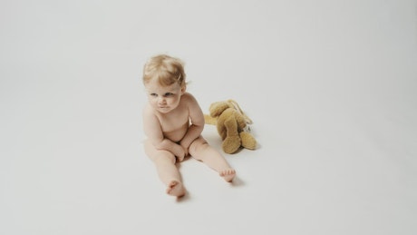 Little blonde baby and a plushie.